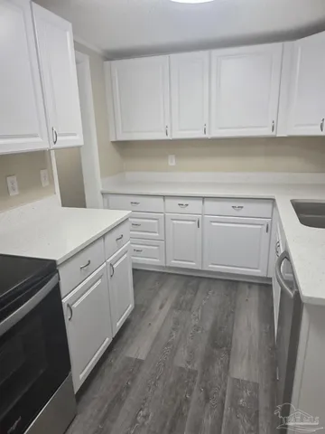 a kitchen with white cabinets and white appliances