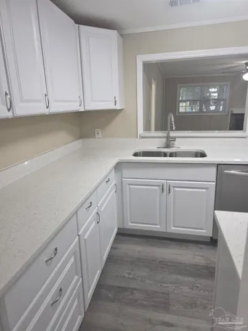 a kitchen with white cabinets and sink