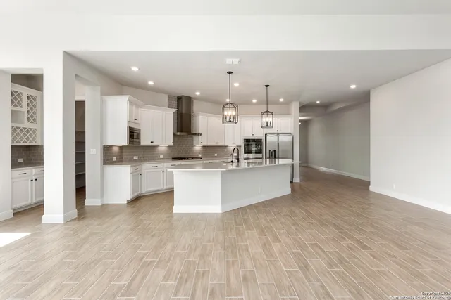 a large kitchen with stainless steel appliances kitchen island a large counter top and a sink