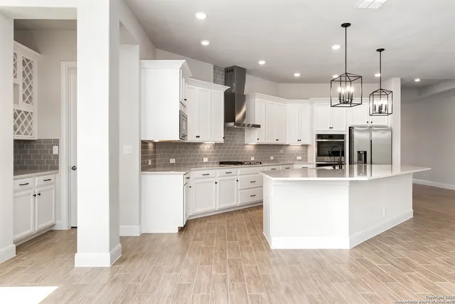 a large kitchen with granite countertop a white stove top oven and cabinets