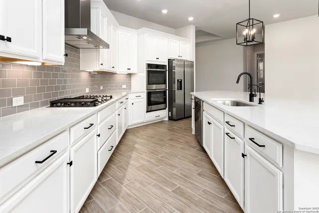 a large kitchen with stainless steel appliances granite countertop a stove and a sink