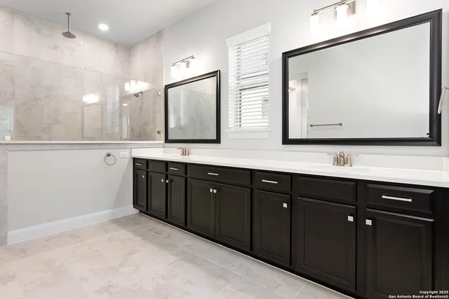 a bathroom with a double vanity sink and a mirror