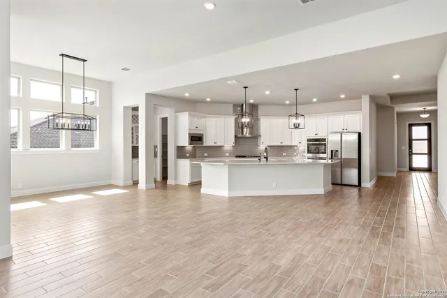 a view of kitchen with kitchen island and stainless steel appliances