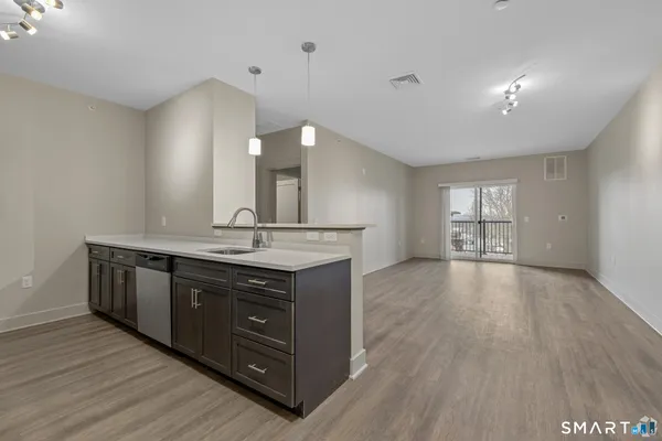 a kitchen with a sink and wooden floor