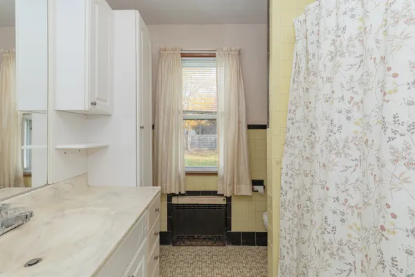 a bathroom with a granite countertop sink a mirror and a bathtub