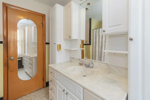 a bathroom with a granite countertop sink and a mirror