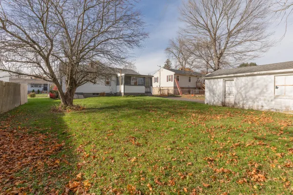 a view of a yard with a house and a large tree