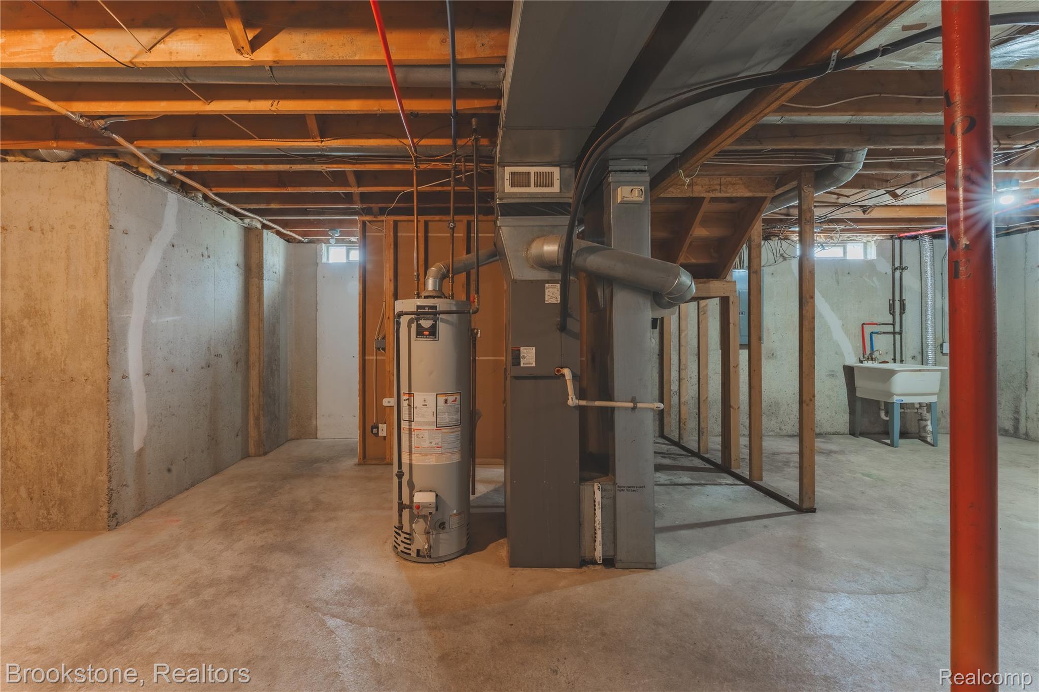 270 Franklin Road Pontiac, MI 48341 - Photo 35 of 46 Unfinished basement featuring exposed wood joists, concrete walls, a utility sink, water heater, and furnace unit