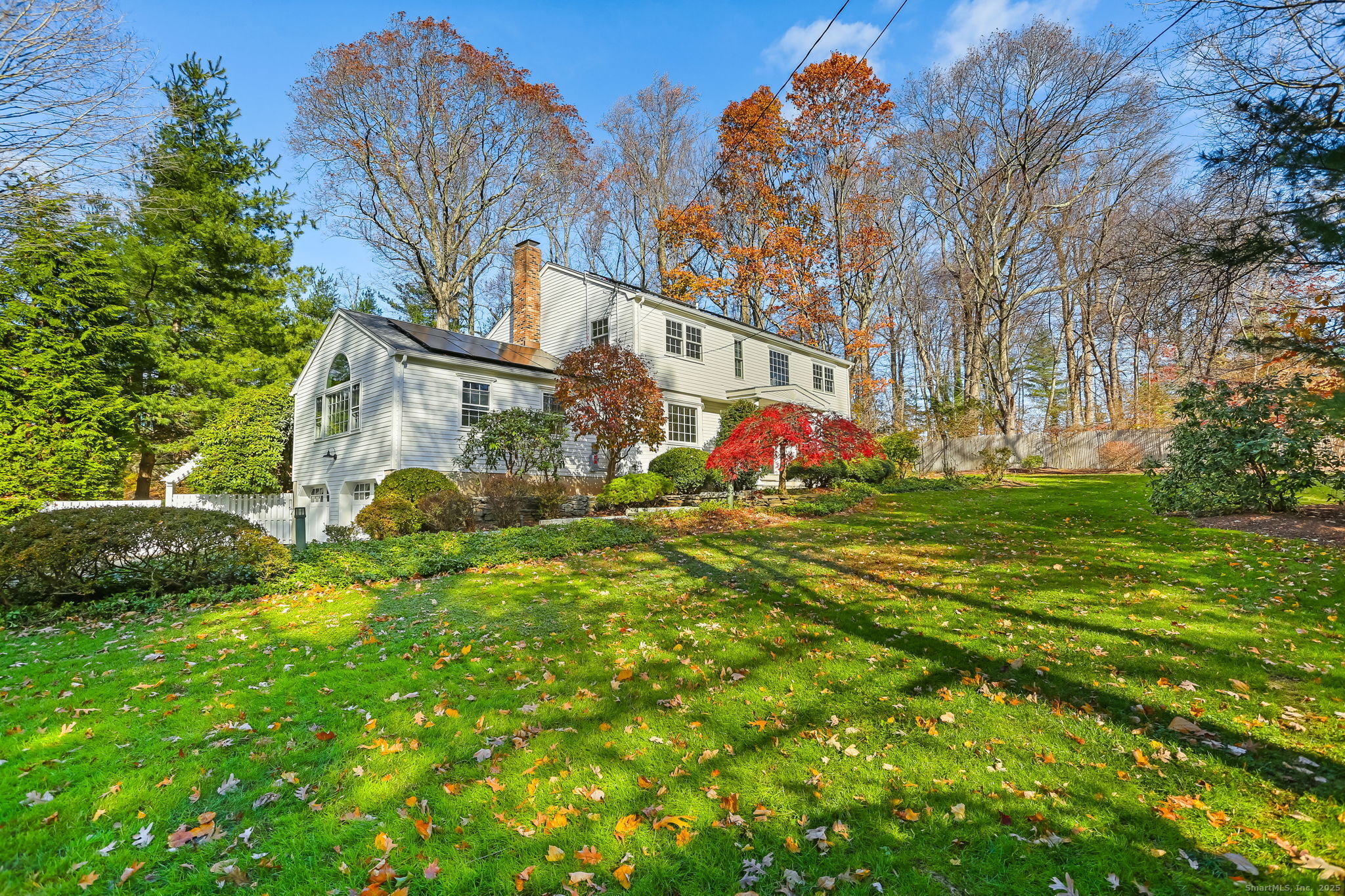 a view of a house with a big yard and large trees