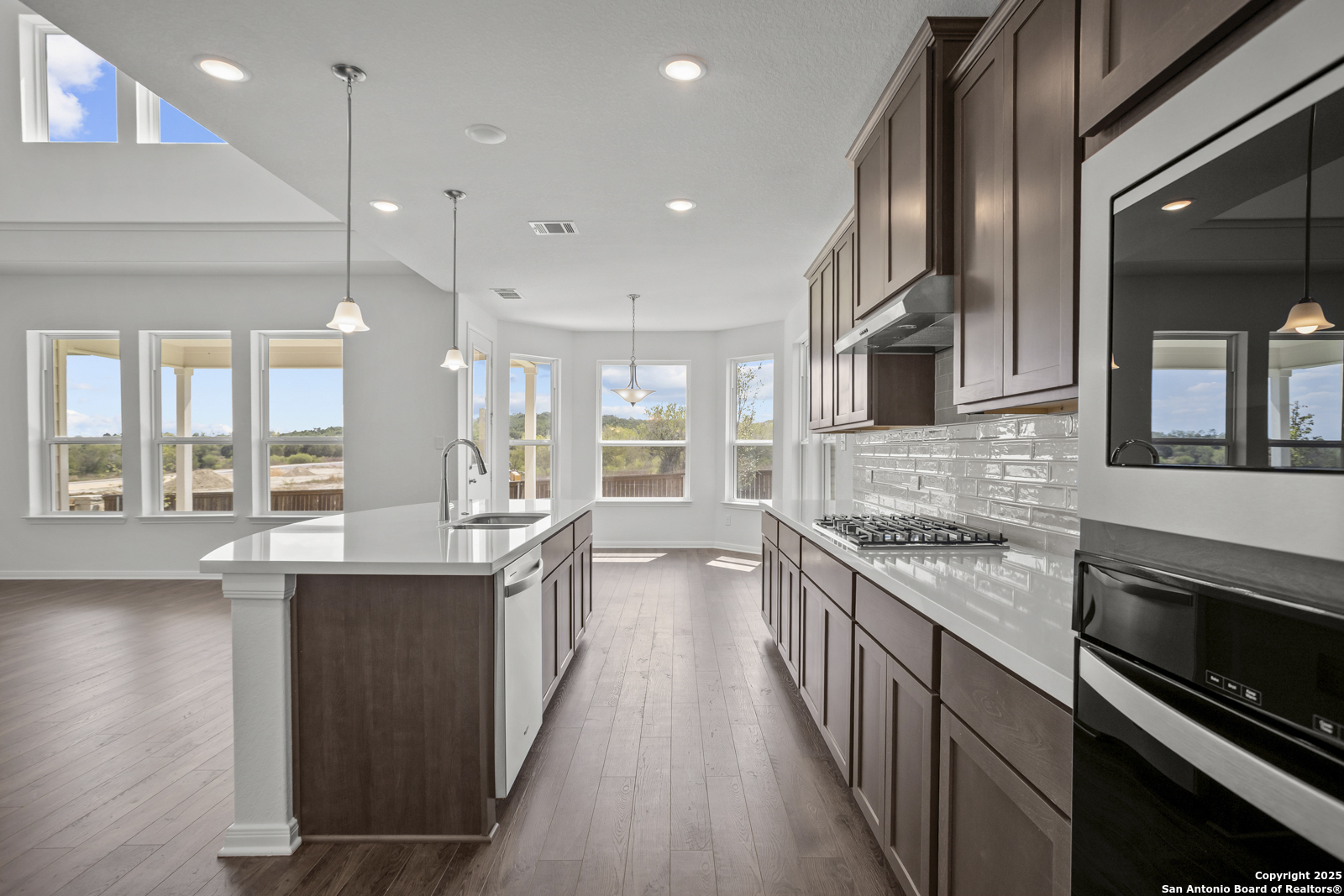 2804 Reeves Lane Schertz, TX 78108 - Photo 12 of 44 a kitchen with stainless steel appliances granite countertop lots of counter top space and wooden floors
