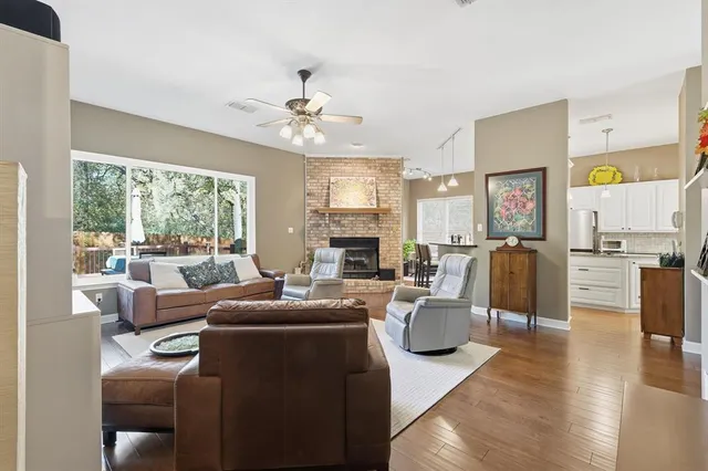 a living room with fireplace furniture and a large window