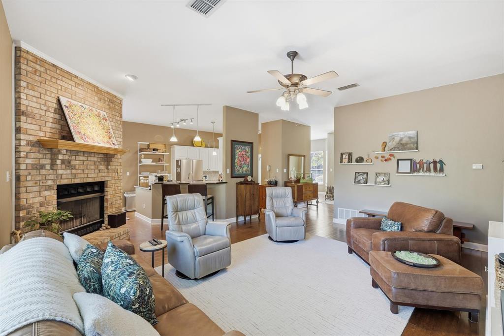 1311 Wilderness Street Denton, TX 76205 - Photo 14 of 40 a living room with furniture a fireplace and a chandelier