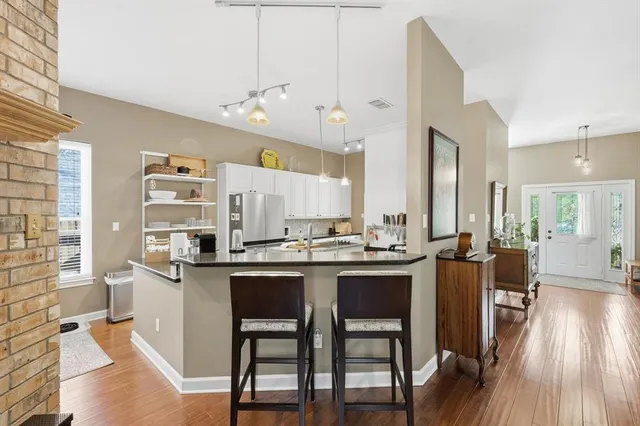 a kitchen with stainless steel appliances a dining table chairs stove and cabinets