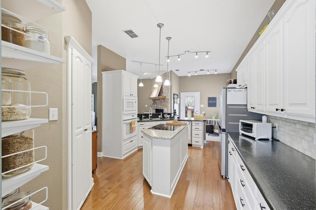 1311 Wilderness Street Denton, TX 76205 - Photo 17 of 40 a view of a kitchen with kitchen island stainless steel appliances sink stove and refrigerator