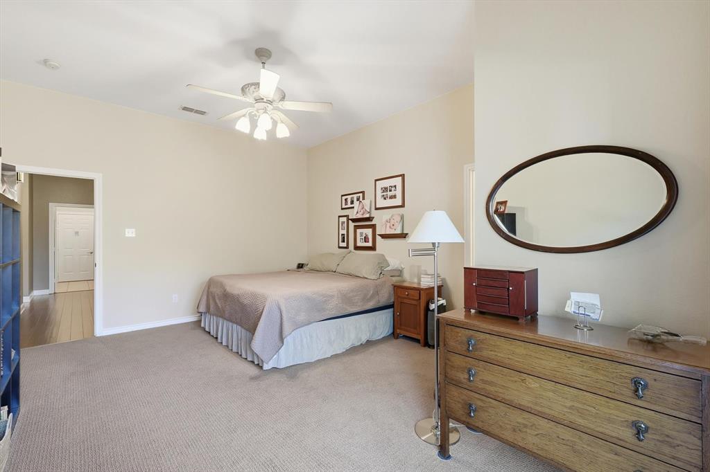 1311 Wilderness Street Denton, TX 76205 - Photo 23 of 40 a bedroom with a bed and a chandelier
