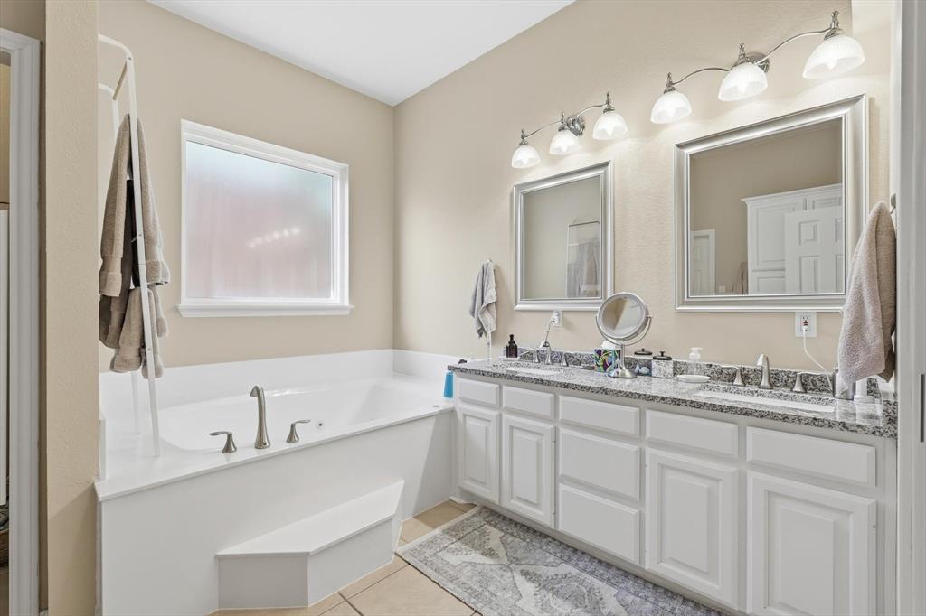 1311 Wilderness Street Denton, TX 76205 - Photo 24 of 40 a bathroom with a double vanity sink mirror and bathtub