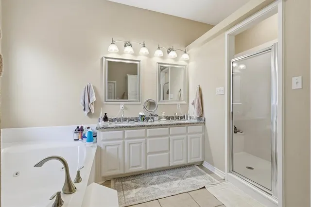 a bathroom with a double vanity sink mirror and shower