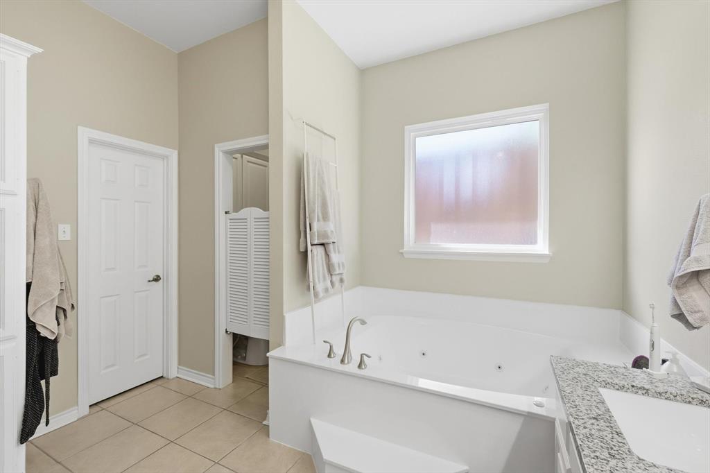 1311 Wilderness Street Denton, TX 76205 - Photo 26 of 40 a bathroom with a tub a sink and a mirror