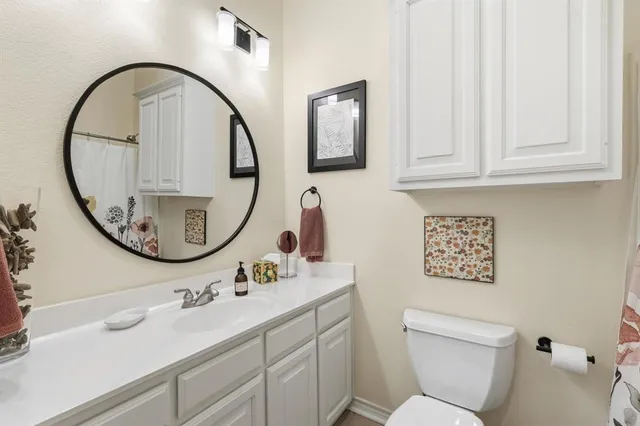 a bathroom with a toilet a sink and a mirror