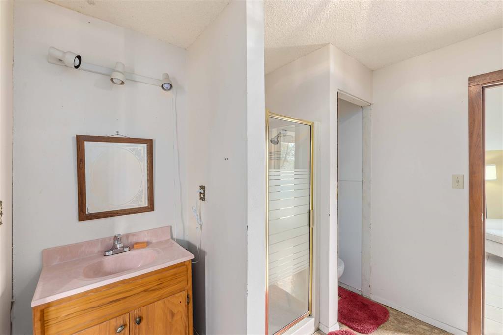 660 County Road 549 Mullin, TX 76864 - Photo 17 of 40 a bathroom with a granite countertop sink and a mirror
