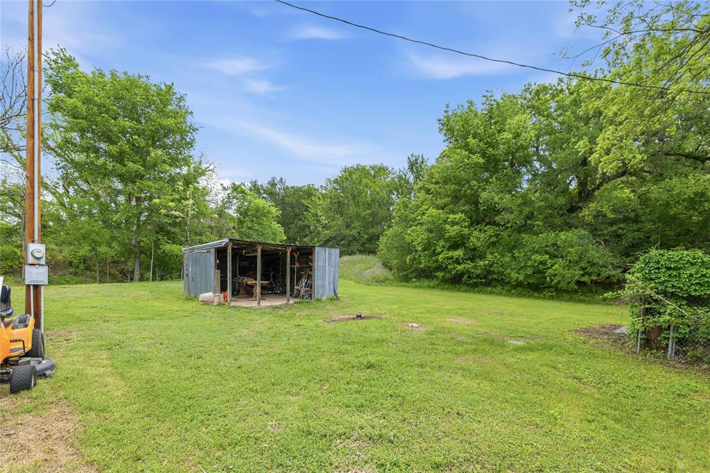 660 County Road 549 Mullin, TX 76864 - Photo 31 of 40 a white house with a big yard and large trees with wooden fence