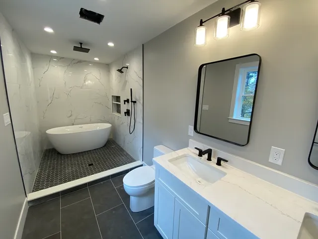 a spacious bathroom with a toilet sink and mirror