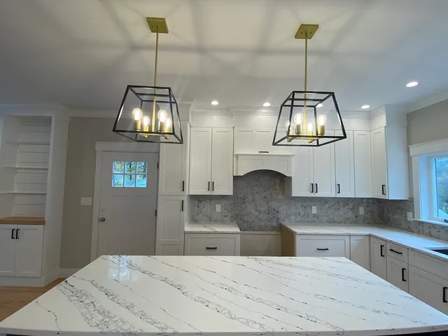 a kitchen with stainless steel appliances granite countertop cabinets a sink and a wooden floor