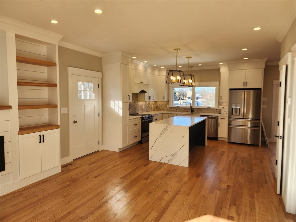 63 Montclair Avenue Waltham, MA 02451 - Photo 4 of 23 a kitchen with stainless steel appliances granite countertop a refrigerator a sink dishwasher and a stove with wooden floor