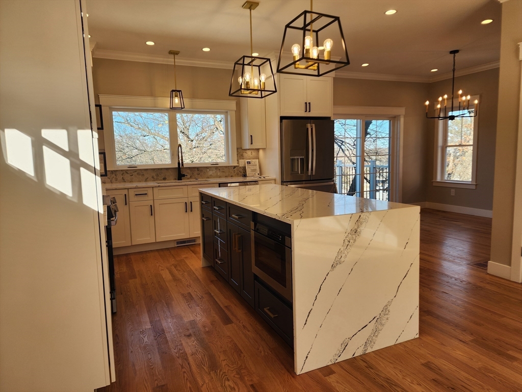 63 Montclair Avenue Waltham, MA 02451 - Photo 6 of 23 a kitchen with stainless steel appliances granite countertop wooden floors and sink