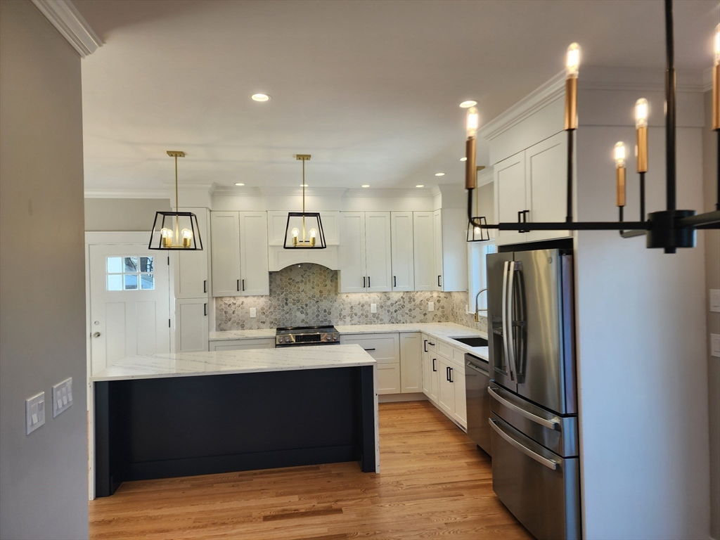 63 Montclair Avenue Waltham, MA 02451 - Photo 8 of 23 a kitchen with stainless steel appliances kitchen island granite countertop a refrigerator and a sink