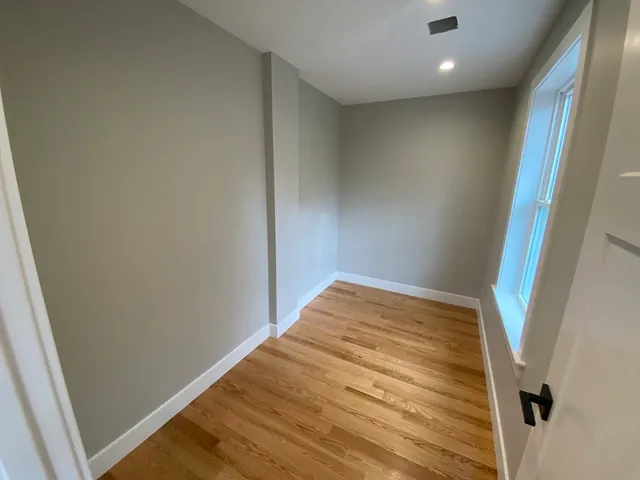 a view of empty room with wooden floor