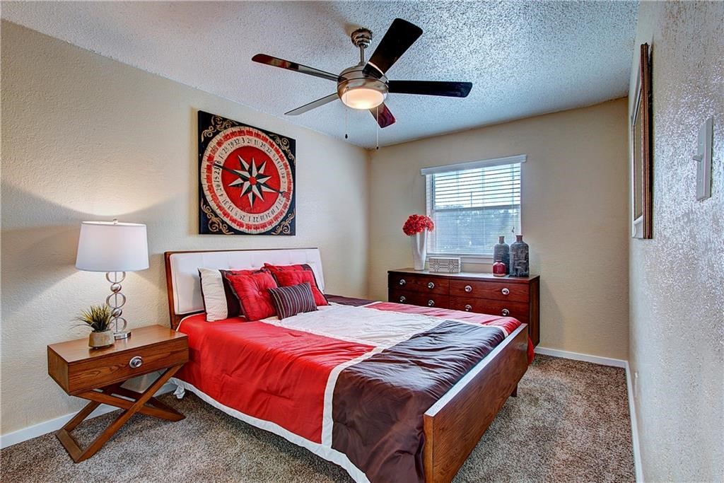 2401 Manor Road, Unit 112 Austin, TX 78722 - Photo 2 of 8 a bedroom with a bed and a chandelier