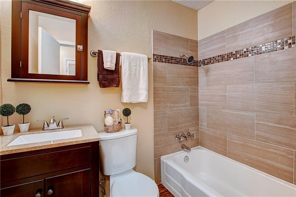 2401 Manor Road, Unit 112 Austin, TX 78722 - Photo 6 of 8 a bathroom with a sink a toilet and shower