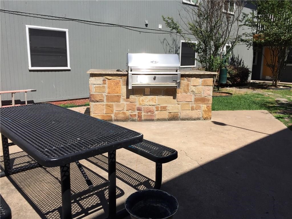 2401 Manor Road, Unit 112 Austin, TX 78722 - Photo 7 of 8 a backyard of a house with yard fire pit barbeque oven and outdoor seating