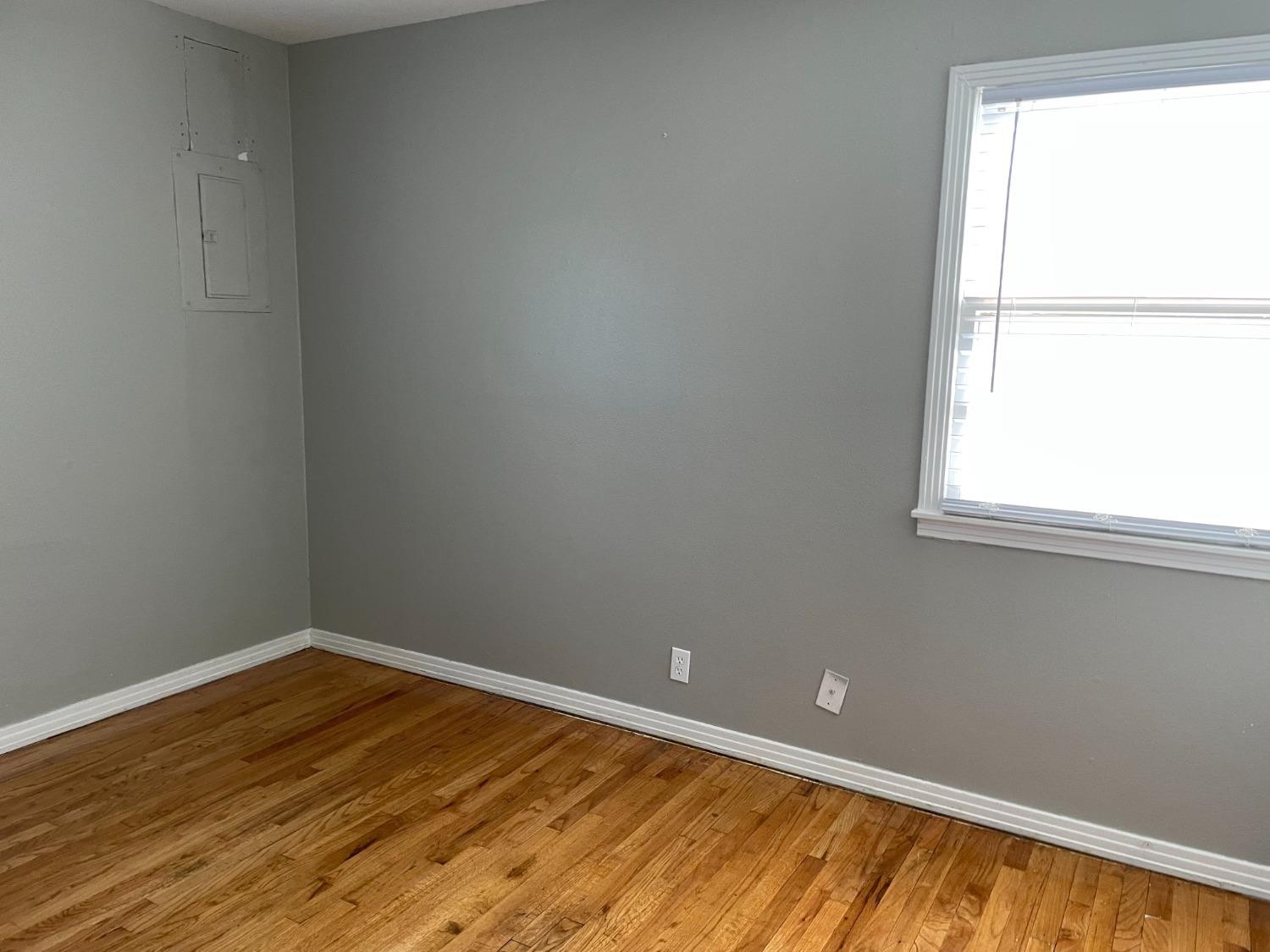6501 Avenue T Lubbock, TX 79412 - Photo 18 of 20 a view of an empty room with wooden floor and a window
