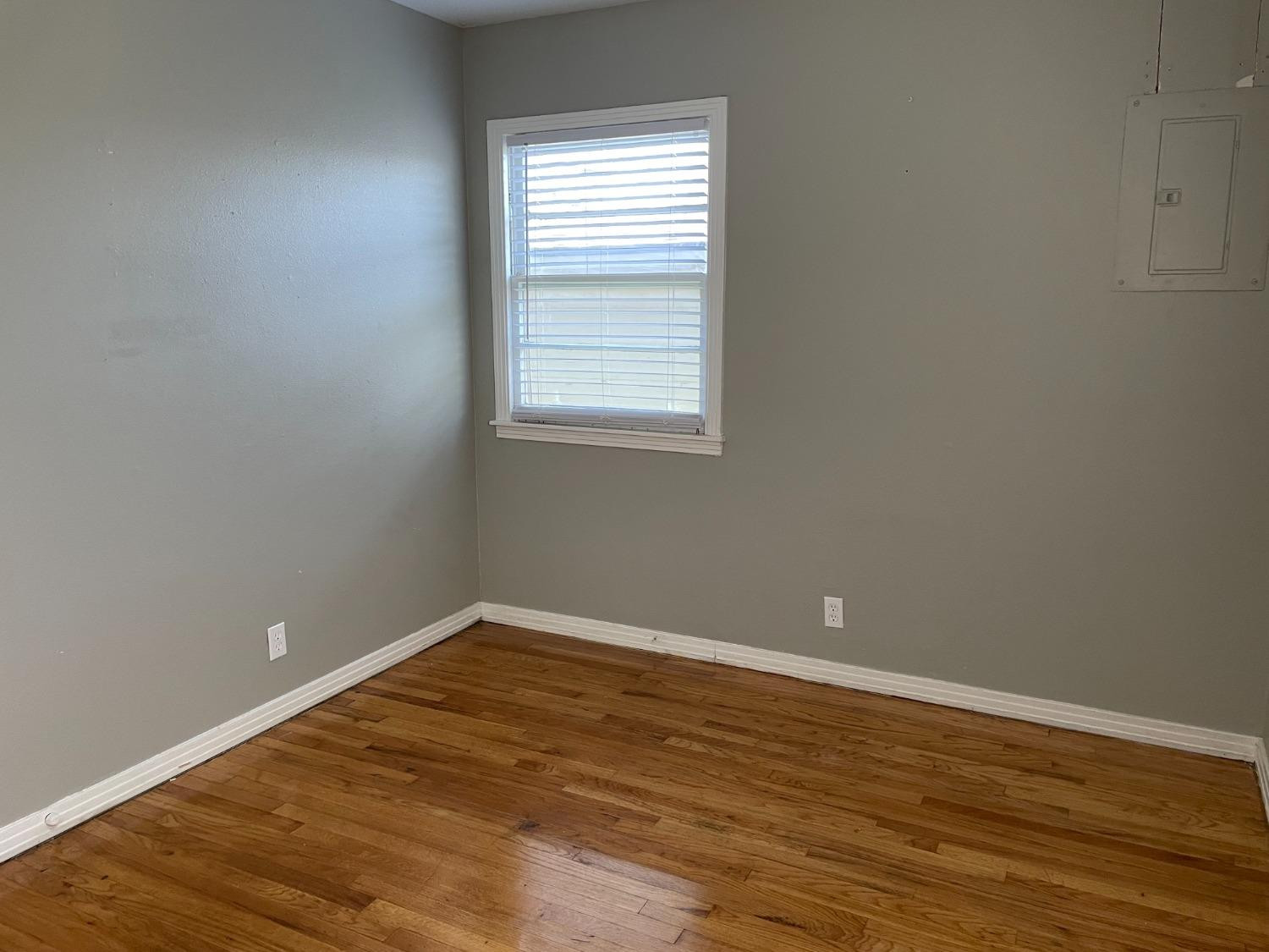 6501 Avenue T Lubbock, TX 79412 - Photo 19 of 20 an empty room with wooden floor and windows