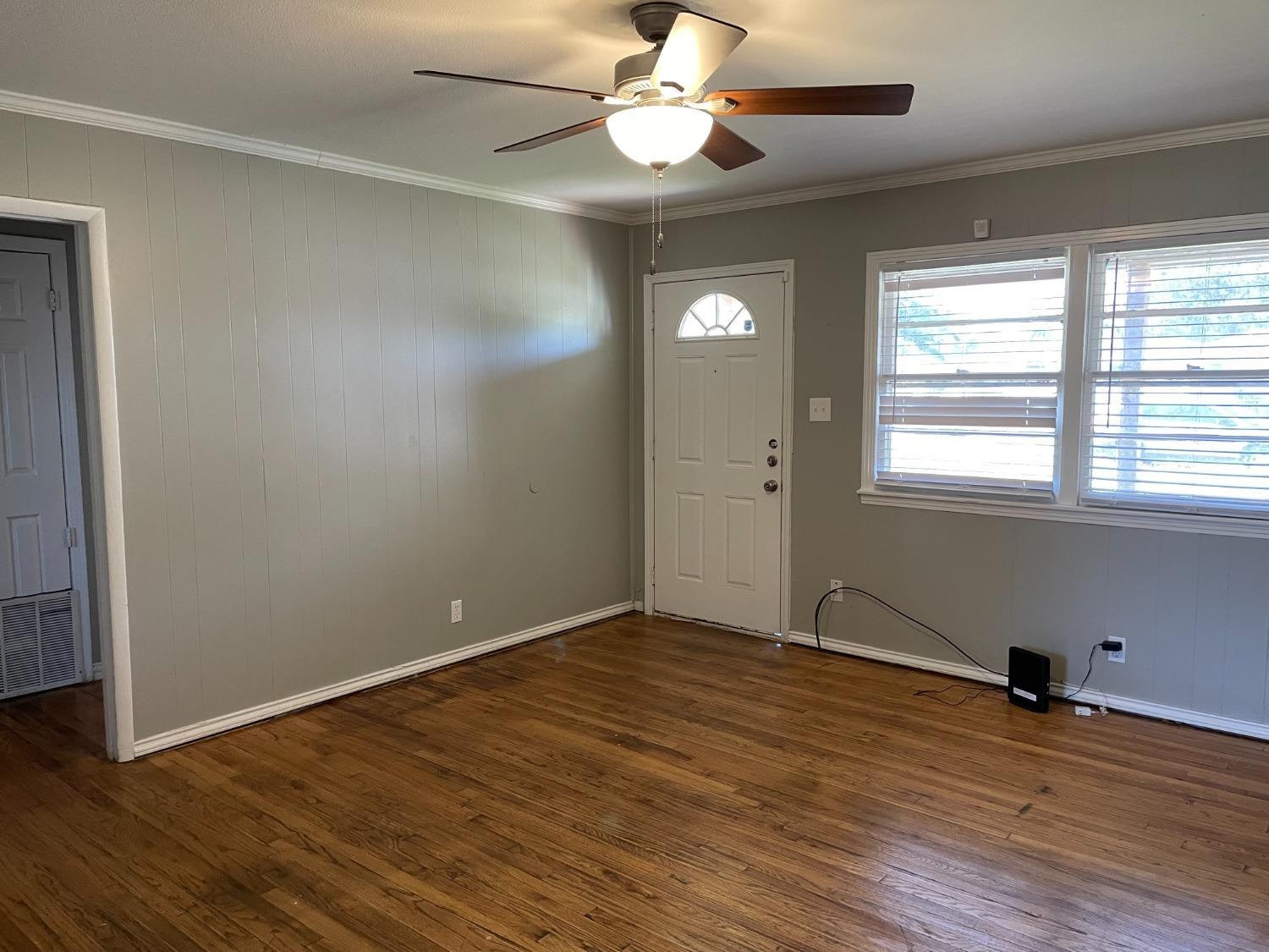 6501 Avenue T Lubbock, TX 79412 - Photo 4 of 20 an empty room with wooden floor fan and windows