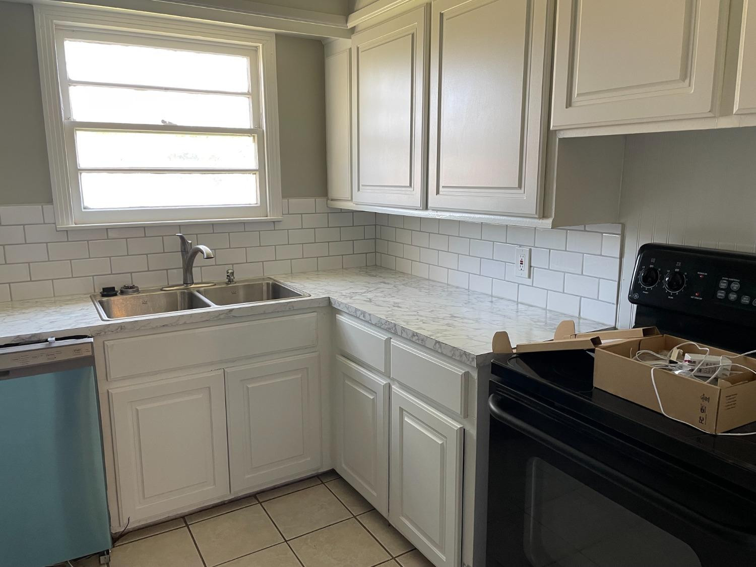 6501 Avenue T Lubbock, TX 79412 - Photo 6 of 20 a kitchen with stainless steel appliances granite countertop a sink stove and cabinets