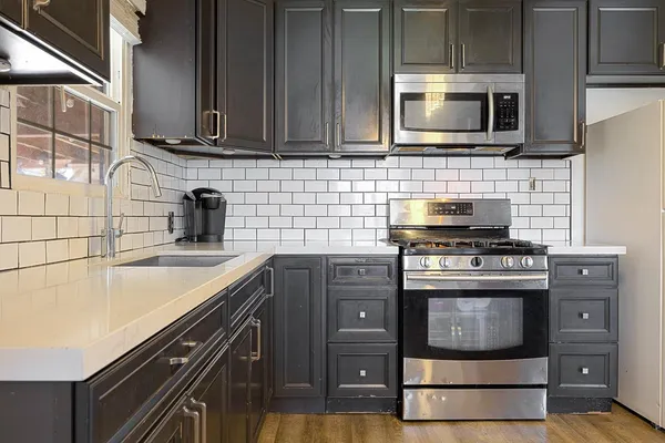 a kitchen with stainless steel appliances granite countertop a stove and a microwave