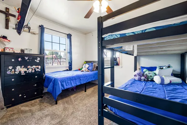 a bedroom with a bed and large windows
