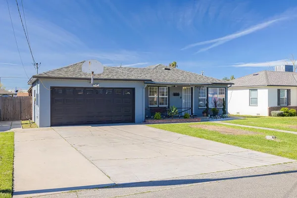 a front view of a house with a garden and yard