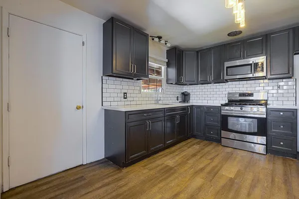 a kitchen with stainless steel appliances a stove a sink dishwasher a refrigerator and a microwave oven