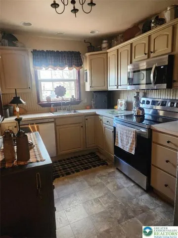 a kitchen with stainless steel appliances granite countertop a sink stove and cabinets