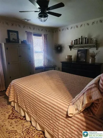 a bedroom with a bed and a ceiling fan