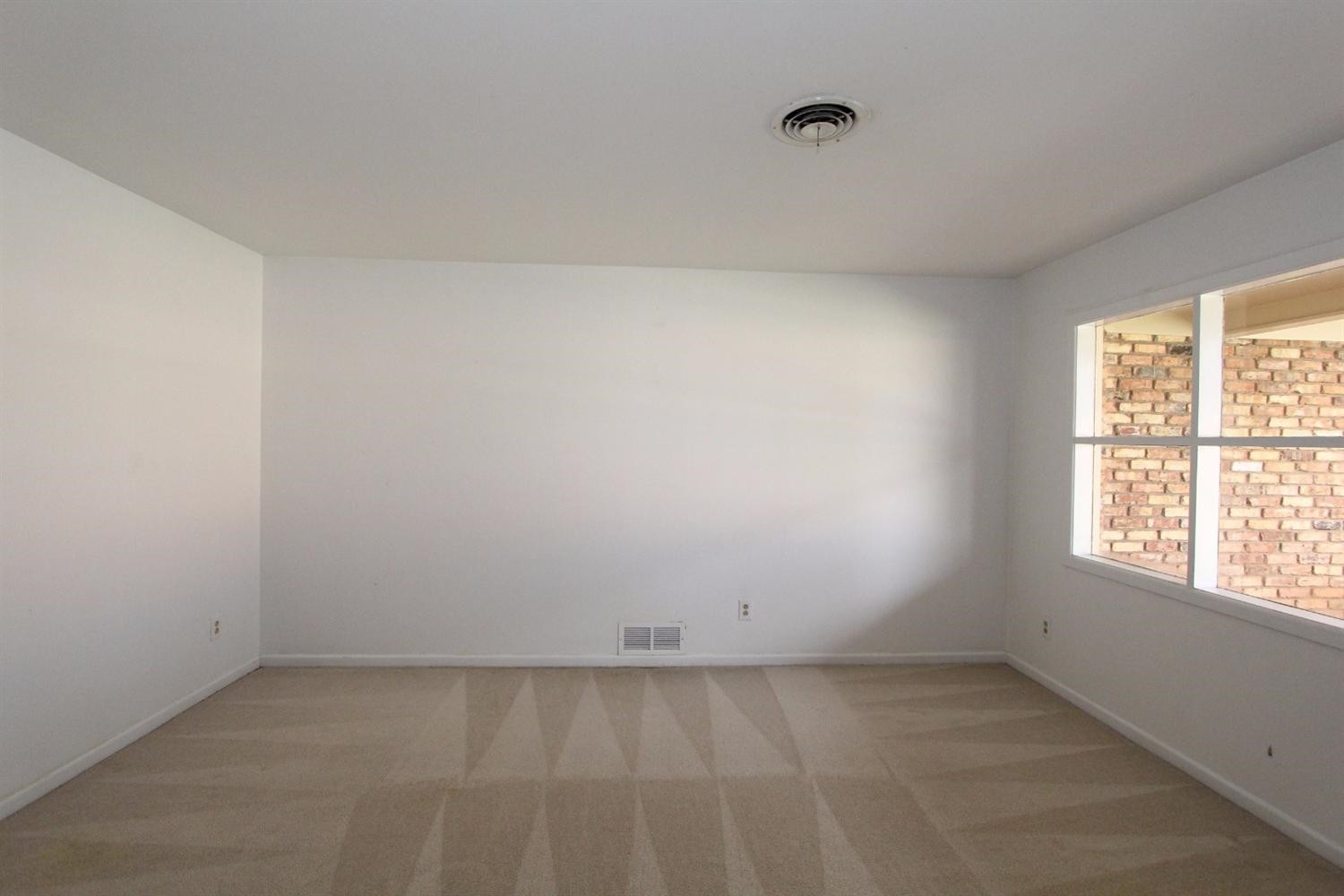 4711 27th Street Lubbock, TX 79410 - Photo 4 of 10 an empty room with a window