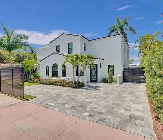 a view of a white house with a yard and potted plants