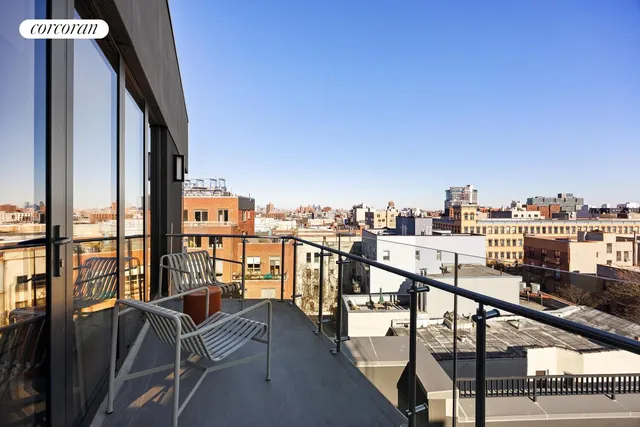 a view of roof deck with seating space and city view