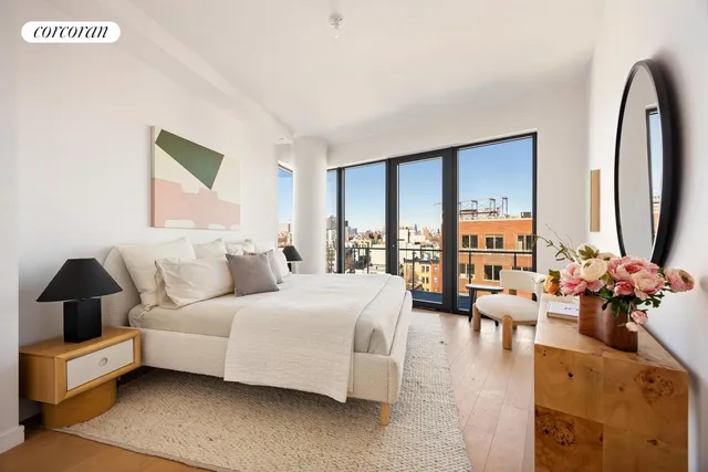 a spacious bedroom with a bed a couch and a large window