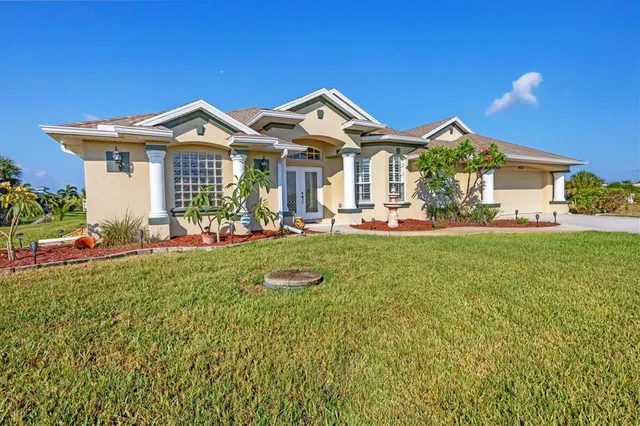 a front view of a house with a big yard and potted plants