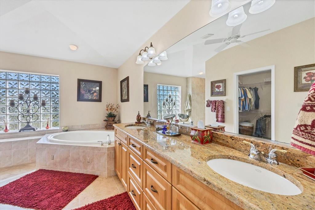 14091 Peekskill Avenue Port Charlotte, FL 33981 - Photo 21 of 53 a spacious bathroom with sinks mirror and a bathtub